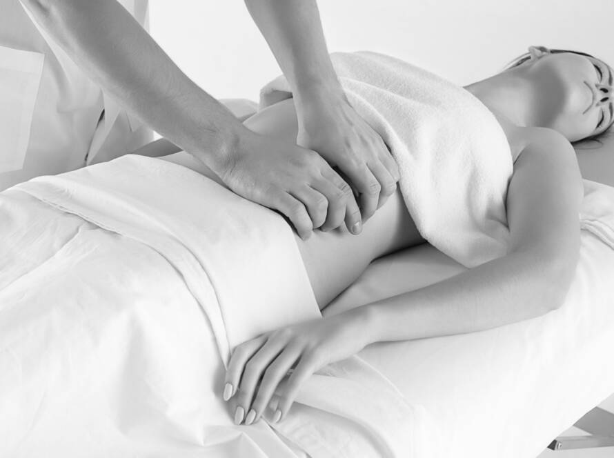 Black and white image of a woman receiving a full body massage.